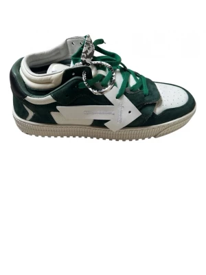 Off-White gröna och vita sneakers - Säljer ett par feta Off-White sneakers i grönt och vitt med ikonisk pil-logga på sidan. Skorna har gröna mockadetaljer, vita partier i läder och gröna skosnören. Klassisk Off-White tag och robust sula. Perfekta för dig som vill sticka ut med streetwear-vibe.                                                     !Storlek passar 43!     !Använda 4ggr!