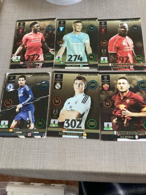 Samling Limited Edition fotbollskort 13/14 kan sälja styckvis förhandling via meddelande  - Säljer en samling Limited Edition fotbollskort från Champions League med spelare från lag som Liverpool, Real Madrid, Chelsea, Bayern München och fler. Korten har färgstarka bilder, guldiga detaljer och statistik på framsidan. Perfekt för dig som gillar att samla fotbollsprylar!