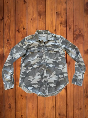 Vintage Hollister Overshirt (sällsynt) - Säljer nu denna vintage sällsynta och asfeta overshirten från Hollister. Den är sjukt fet och har riktigt snygga slitningar vilket ger en unik look, en perfekt overshirt till våren nu när det börjar bli varmare. Den är i otroligt bra skick och storlek är XS och se måtten nedan B=63cm A=48cm