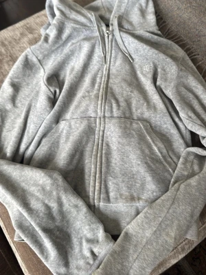 Grå zip hoodie med huva - Säljer en knappt andvänd juciy couture kofta andvönd max 3 gånger. Den passar mig som har storlek xs till m passar till allt tveka inte höra av dig vid frågor❤️