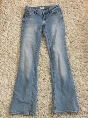 Lågmidjade bootcut jeans från ONLY - Säljer ett par ljusblå bootcut jeans från ONLY med klassisk femficksdesign och låg midja. Jensen har inga tecken på användning. 