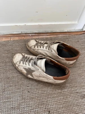 Ett par väldigt slitna golden goose skor - Säljer ett par slitna golden goose skor. Hade egentligen tänkt slänga dem, men för den som har tid och vill lägga ner lite pengar går dem nog att fixa upp och använda eller återförsälja. Skorna har flera defekter och behöver förmodligen sys, tvättas rejält, kanske målas och eventuellt byte av snören. Originalsulor saknas, men box och påse finns kvar. Skriv för fler bilder och mer info!