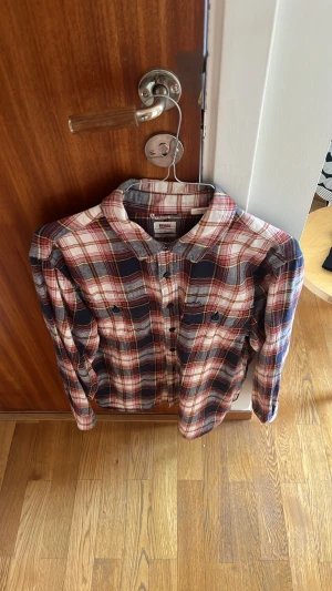 Rutig skjorta från Levi's i bomull - Riktigt snygg rutig skjorta från Levi's i mjuk bomull. Skjortan har långa ärmar, klassisk krage, knappar framtill och två bröstfickor. Färgkombon är marinblå, röd och vit vilket ger en tidlös vibe. Perfekt för dig som gillar avslappnad och trendig stil.