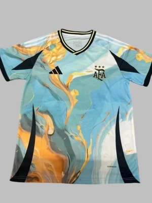 Argentina AFA fotbollströja Adidas - Säljer en unik Argentina AFA fotbollströja från Adidas med ett färgstarkt mönster i blått, gult och vitt. Tröjan har svarta detaljer, korta ärmar och V-ringning. Tillverkad i lätt och ventilerande material, perfekt för träning eller match. Du kan bestämma vilken storlek du vill ha!!! Det kan ta upp till 15-20 dagar till att tröjan är framme!!!