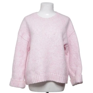 Ljusrosa stickad tröja från Monki - Mysig ljusrosa stickad tröja med rund halsringning och ribbade muddar vid ärmslut och nederkant från Monki . Tröjan har en avslappnad passform och är perfekt för att hålla värmen under kyliga dagar. Materialet känns mjukt och fluffigt.