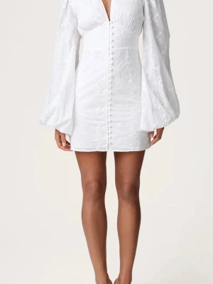 Adoore klänning. - Stilren vit kort klänning med v-ringning, puffiga långärmar och knappar framtill. Klänningen har ett subtilt blommigt mönster och markerad midja för en snygg siluett.   👈AI . Jag👉   Säljer nu min ÄKTA Adoore klänning då jag hade tänkt att ha den till studenten men har hittat en annan jag ville ha istället då jag kände att den va lite kort (179cm lång) . Aldrig använd och har till o med prislappen kvar endast testat 2 gånger. Vid intresse skriv så får ni bild bevis på att jag har den klänningen💕