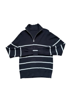 Half zip - Snygg marinblå stickad tröja med vita horisontella ränder och halv dragkedja vid halsen. Tröjan har hög krage och långa ärmar, perfekt för en stilren och avslappnad look. Materialet känns mjukt och bekvämt mot huden.