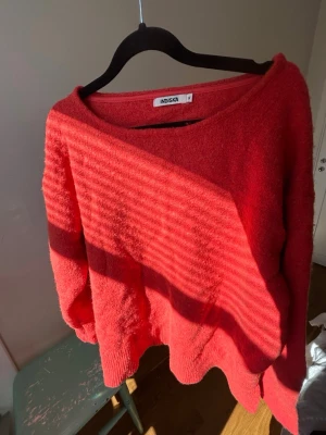 Röd oversized stickad tröja Indiska - Mysig röd stickad tröja från Indiska med avslappnad, oversized passform och bred rund halsringning. Tröjan har långa ärmar och ribbade muddar vid ärmslut och nederkant. Perfekt för lager på lager och chill stil🥂💗