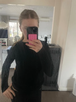 Svart stickad tröja från Daisy Grace - Säljer en svart stickad tröja från Daisy Grace med coolt bubbelmönster över hela plagget. Tröjan har rund halsringning, långa ärmar och ribbade muddar vid ärmslut och nederkant. Den är tajt i armarna💗