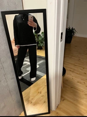 Svart set - Mysigt svart -set med långärmad tröja och vida byxor. Setet har vita detaljer längs ärmslut och nederkant på tröjan. 