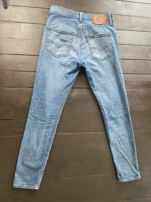 Levi's ljusblå raka jeans 512 - strl 29/32 - Säljer dessa snygga Levi’s jeans av modell 512 i storlek 29/32. Dem är generellt i bra skick utöver en liten fläck på benet som knappast märks av vid användning. Innerbenslängden är 75cm. Benöppningen är 30cm och midjan är 74cm. Priset går att diskuteras. 
