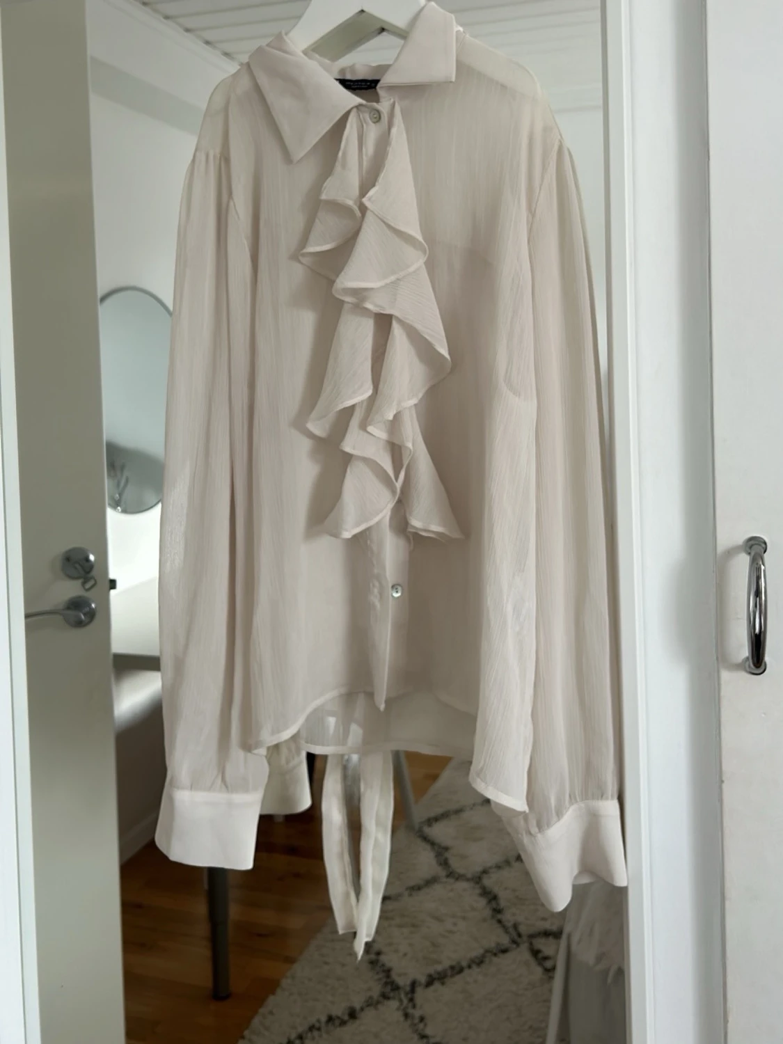 Vit blus med volang och knytband
