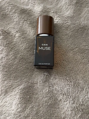 CAIA Muse Eau de Parfum brun flaska - Snygg parfym från CAIA i doften Muse. Flaskan är rektangulär och gjord av brunt glas med ett matchande brunt lock. Modern och stilren design som passar perfekt på sminkbordet. Eau de Parfum-varianten ger en långvarig doft. 15ml