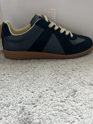 Mason margielas  - Säljer dessa sjukt feta marin blå margiela skor till ett väldigt bra pris. Dem är använda ett fåtal gånger och är i ett jätte bra skick. Vill sälja dem då jag köpte fel storlek. Kom med pris förslag 