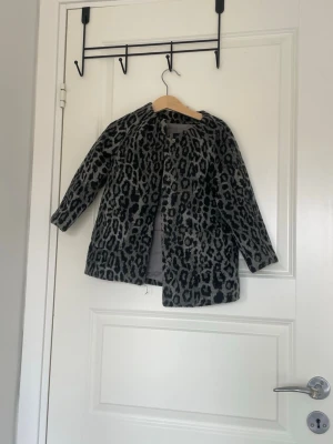 liten kappa för barn - Säljer denna jättegulliga lilla kappan ifrån hm med leopard mönster i grått. Är för barn mellan 3-4 år.