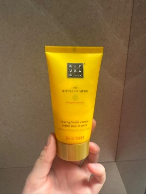 Rituals The Ritual of Mehr body cream - Fräsch och energigivande body cream från Rituals, The Ritual of Mehr. Kommer i en gul tub på 70 ml och doftar söt apelsin och cederträ. Perfekt för dig som vill ha en återfuktande och väldoftande hudkräm i snygg förpackning.