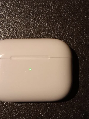 Apple AirPods Pro med tillbehör - Säljer ett par Apple AirPods Pro med vitt laddningsetui, extra silikonpluggar, laddningskabel (USB-C till Lightning) och handledsrem. Hörlurarna har en stilren, kompakt design i blank vit plast och passar perfekt för trådlös musik och samtal. Pris kan diskuteras.