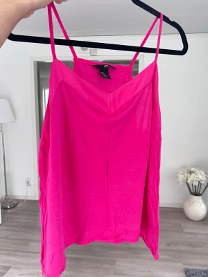 Rosa linne, stl M  - Säljer ett snyggt rosa linne med v-ringning och smala axelband. Chockrosa färg 🩷