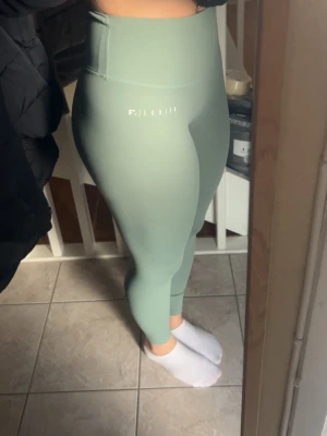 Gröna seamless leggings från Relode - Snygga gröna seamless tights från Relode med hög midja och diskret logga framtill. Tightsen har även en bakficka där mobil får plats. 