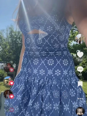 Blå blommig kortklänning - Supersöt blå kortklänning med vitt blommönster och en liten cut-out detalj framtill. 