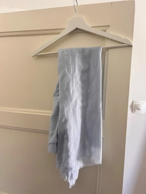 Ljusblå stilren sjal - Ljusblå stilren sjal i tunt fint tyg från Åhléns.  Endast testad, så i fint skick.