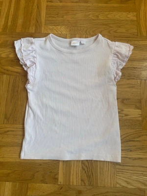 Ljusrosa ribbad topp från Gina Tricot💕💕 - Säljer en supersöt ljusrosa topp från Gina Tricot med ribbad struktur och volangdetaljer på de korta ärmarna💕💕💕💕Materialet känns mjukt och stretchigt, och toppen har rund halsringning💕💕💕I mycket bra skick💕💕Jag säljer den för 40 kr💕💕Hör av er vid intresse💕💕