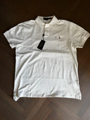  Polo Ralph Lauren pikétröja  - Helt ny piké från Ralph Lauren, i färgen Parchment Cream. Säljer då den va för stor, aldrig använd, endast provad. Har kvar kvitto.