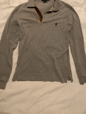 Grå långärmad piké från Ralph Lauren - Säljer en grå långärmad pikétröja från Polo Ralph Lauren i slim fit stretch mesh. 