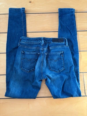 Replay New Luz Jeans – W26 L32 – Slim Fit – Mörkblå Denim - Säljer ett par stilrena Replay New Luz jeans i snygg mörkblå tvätt.  Storlek: W26 L32 Passform: Skinny/Slim fit med stretch Färg: Mörkblå denim Skick: Bra skick med normal användning  Sitter snyggt på kroppen och passar perfekt till både vardag och mer uppklädda outfits. Klassiska Replay jeans med stilren design och bekväm passform.  Perfekta om du söker prisvärda märkesjeans med snygg tvätt.  Pris: 199 kr  Skriv gärna vid frågor eller om du vill ha fler bilder/mått. Snabb affär prioriteras.
