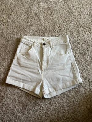 Vita högmidjade shorts  - Snygga vita shorts med hög midja. Tillverkade i mjuk bomull. Älskar men försmå. Passar även som S