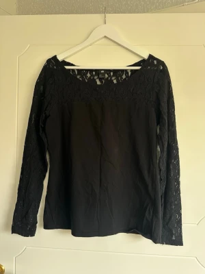 Tröja - Tröja med spets. En tråd som börjat gå upp framtill. (Se bild)