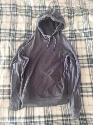  Hoodie från DNMD med ficka - Säljer en stilren blå grå hoodie från DNMD i storlek L. Hoodien har en klassisk känguruficka framtill och dragsko i huvan. Använt fåtal gånger.