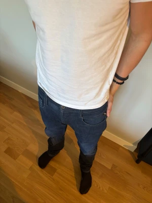 Mörkblå jeans från Replay - Säljer ett par snygga mörkblå replay anbas. med klassisk femficksdesign och smal passform. Jeansen har diskreta fades och logotypdetalj vid fickan. Perfekta för en trendig och avslappnad stil.