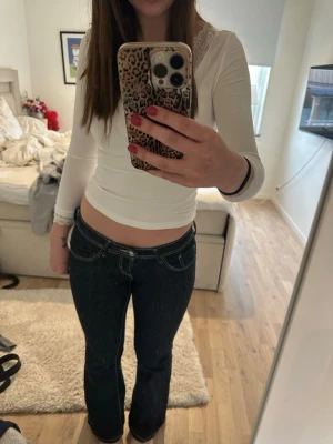 Mörkblå bootcut jeans med vita sömmar - Säljer ett par mörkblå bootcut jeans med tydliga vita kontrastsömmar. Jeansen har låg midja och klassisk femficksdesign. Dem är i längden regular. 💞
