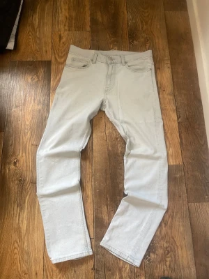 Ljusblå Slim jeans från HM - Säljer ett par ljusblå jeans med rak passform och klassisk femficksdesign. Jeansen har bälteshällor och stängs med knapp och dragkedja. Materialet är denim i bomull och färgen är riktigt fräsch ljusblå, perfekt till en avslappnad stil.