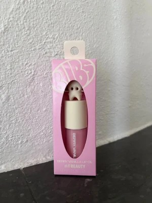BUBS  X HM Beauty Berry Vanilla Lip Oil, 3,3 ml, ny, limiterad upplaga - Läppolja med vanilj doft/smak från H&M Beauty i samarbete med godisföretaget BUBS. Produkten är helt ny och såldes i limiterad upplaga.   3,3 ml Doft/smak: Vanilla