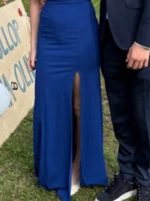 Blå långklänning med slits och rosett - Snygg blå långklänning med djup v-ringning och rosettdetalj framtill. Klänningen har en hög slits som ger en cool look och är ärmlös. Perfekt för dig som vill sticka ut på balen eller festen!