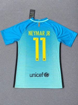 Retro Neymar Jr 2015/2016 bortaställ  - Säljer en riktigt snygg FC Barcelona-tröja med Neymar Jr #11 på ryggen. Bortaställ i turkos/blå design med tunna ränder – en klassisk och populär modell. ✔️ Märke: Nike  ✔️ Lag: FC Barcelona ✔️ Spelare: Neymar Jr ✔️ Storlek: S ✔️ Skick: Helt ny med tags kvar  💬 Hör av dig vid frågor eller för fler bilder! 📦 Snabb frakt