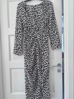 Långärmad leopardklänning från H&M - Snygg långärmad klänning från H&M med svartvitt leopardmönster. Klänningen är lång och har en figurnära passform med markerad midja obs första bilden är bak på klänningen. Perfekt för dig som vill sticka ut💕