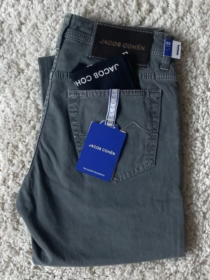 Jacob Cohën ”Bard” Lyx Jeans – Grå – Size 29 (Nya med Tags) - Säljer ett par mycket fina jeans från italienska Jacob Cohën i en stilren grå färg. Nya med tags kvar och aldrig använda. Skriv om du har någon fråga!  • Brand • Jacob Cohën • Modell • Bard • Colour • Grå • Size • 29 Waist • Condition • Ny (Tags kvar)