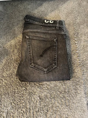 Grå tvättade jeans från Dondup - Säljer ett par grå tvättade jeans från Dondup med klassisk femficksmodell och raka ben. Jeansen har en snygg sliten look. Perfekta för en avslappnad och trendig stil. Modellen är ritchi och storleken är 32/30. Inte alls använda mycket. Ställ gärna frågor😁