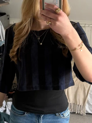 Randig croppad topp från H&M - Snygg croppad topp från H&M med breda svarta och mörkblå ränder. Toppen har trekvartsärm. Skriv om ni har några frågor!💕