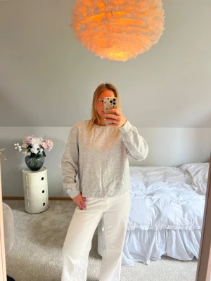 Ljusgrå sweatshirt i basic stil - En enkel och stilren ljusgrå sweatshirt med rund hals och långa ärmar. Tröjan har en avslappnad passform och är tillverkad i mjukt material, perfekt för en chill och casual look. Passar till det mesta och är lätt att matcha med andra plagg.