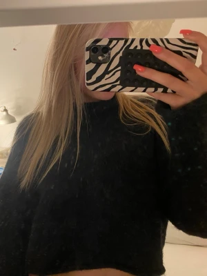 Marinblå croppad stickad tröja - Mysig marinblå croppad stickad tröja med rund hals och långa ärmar. Perfekt till jeans eller kjol för en chill och trendig look. Materialet känns mjukt och skönt mot huden. Enkel och stilren design utan tryck eller detaljer.
