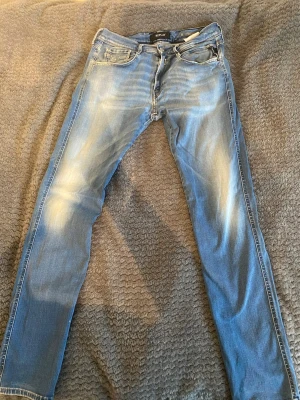 Ljusblå slim fit jeans från Replay - Snygga ljusblå slim fit jeans från Replay med slitningar och tvättade detaljer. Klassisk femficksmodell med dragkedjegylf och raka ben. Perfekta för en avslappnad och trendig look. Materialet är mjukt denim som ger skön passform.         Waist 33         length 34