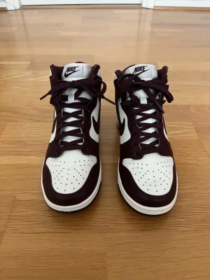 Nike Dunk High skor storlek 40 – Mycket gott skick - Nike Dunk High i mycket fint skick. Skorna är sparsamt använda och väl omhändertagna med minimala tecken på användning. Stilren modell som passar både till vardag och streetwear. Storlek 40. Säljes enligt bilder. Vid frågor eller intresse är det bara att höra av sig.