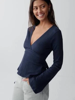 Mörkblå omlottopp med v-ringning - Trendig mörkblå omlottopp med djup v-ringning och långa ärmar. Toppen har en figurnära passform och lätt struktur i tyget, perfekt att styla med jeans eller kjol. Enkel men snygg design som ger en cool vibe.