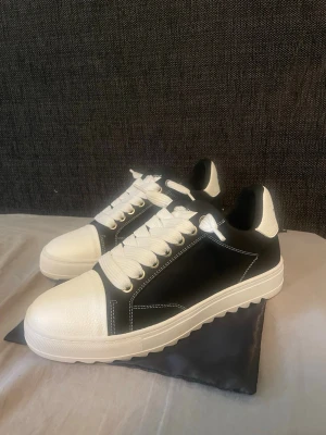 Numeris - Snygga sneakers från Numeris i svart och vitt med kraftig vit sula och vita skosnören. Skorna har kontrasterande vita detaljer på tå och häl samt tydliga vita sömmar. Perfekta för dig som gillar en stilren och modern look.