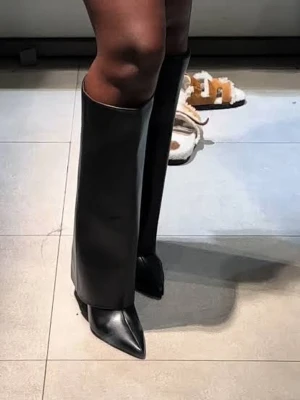 Svarta läder boots - Unika svarta boots med hög och rak skaftdesign, spetsig tå och smal klack. Tillverkade i slätt konstläder som ger en futuristisk och edgy vibe. Perfekta för dig som vill sticka ut och ta din outfit till nästa nivå.