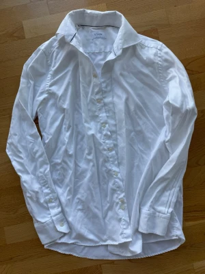 Vit skjorta från Eton - Klassisk vit skjorta från Eton med krage och knäppning framtill. Skjortan har lång ärm och är tillverkad i bomull. Perfekt för en stilren och clean look.